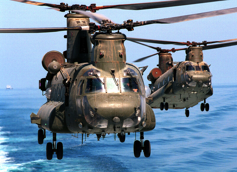 Two military helicopters over ocean