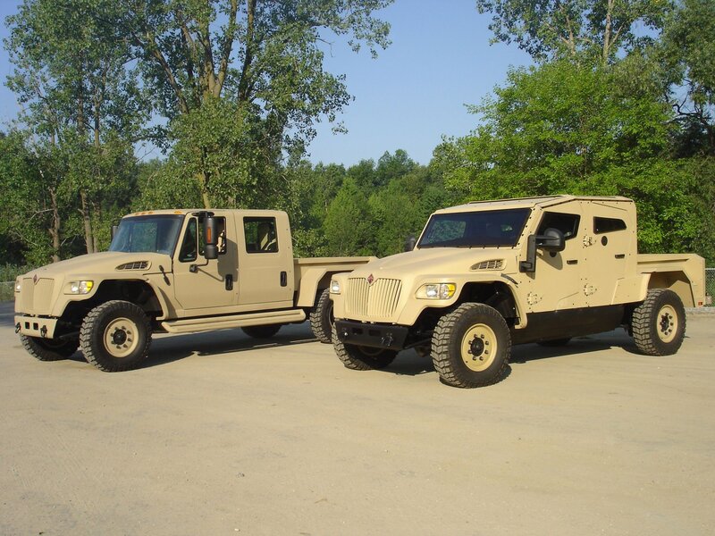 Two military trucks parked outside