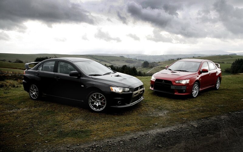 Two Mitsubishi Lancers on a hill