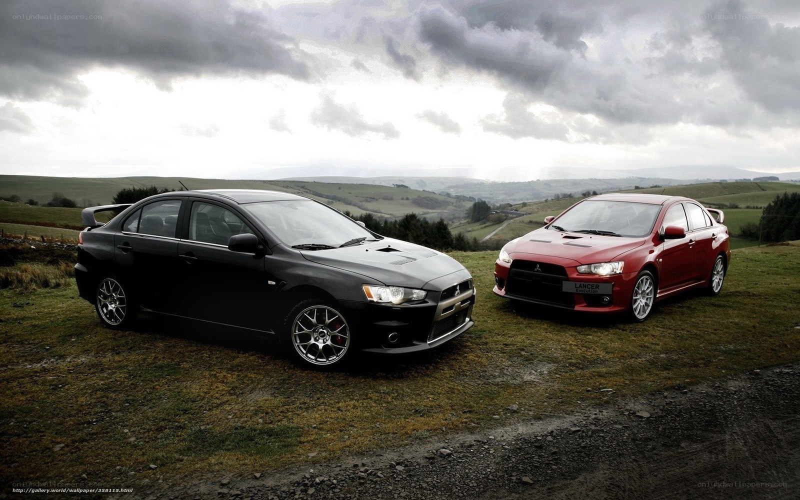 Two Mitsubishi Lancers on a hillside