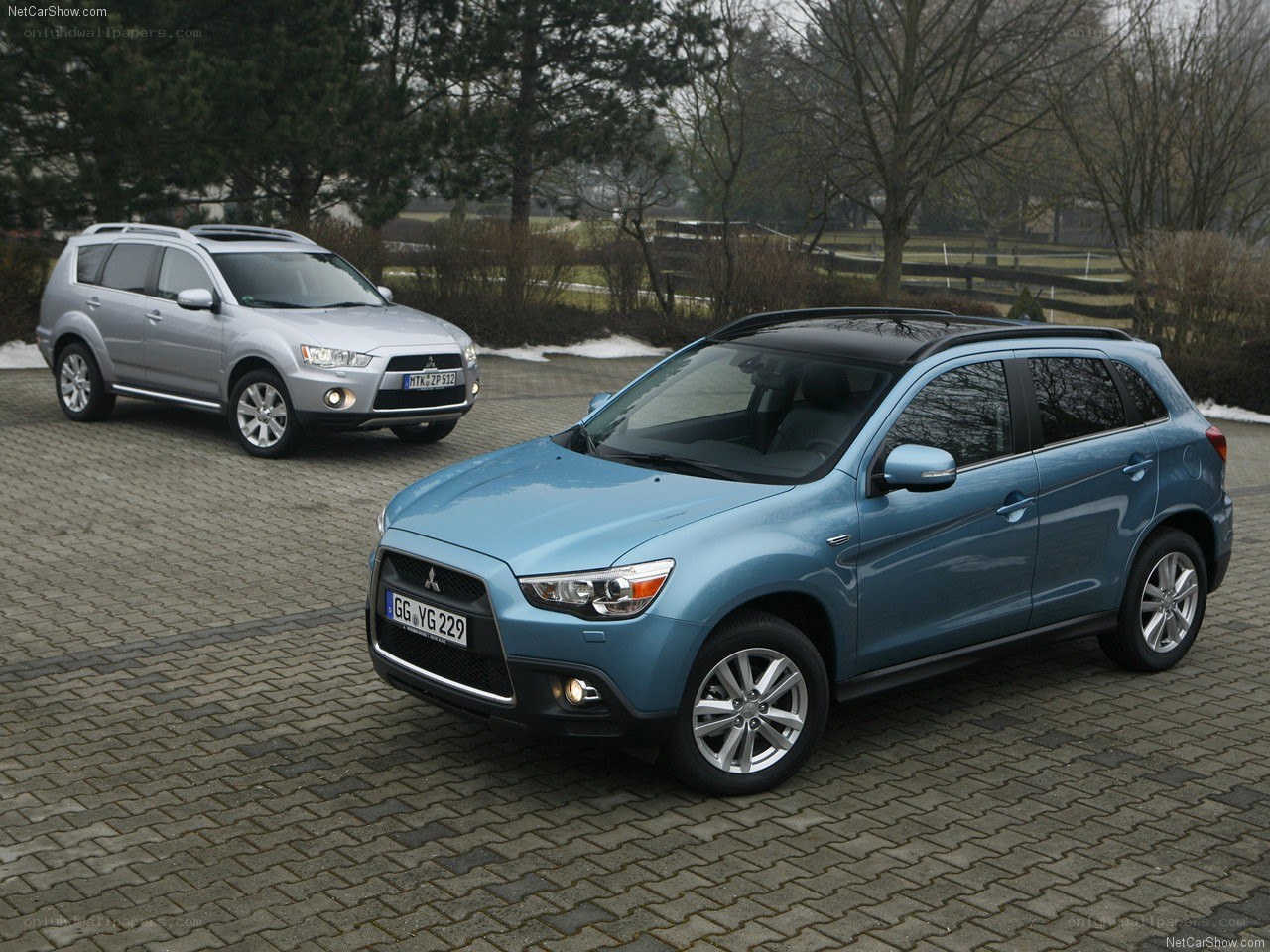 Two Mitsubishi SUVs on a driveway