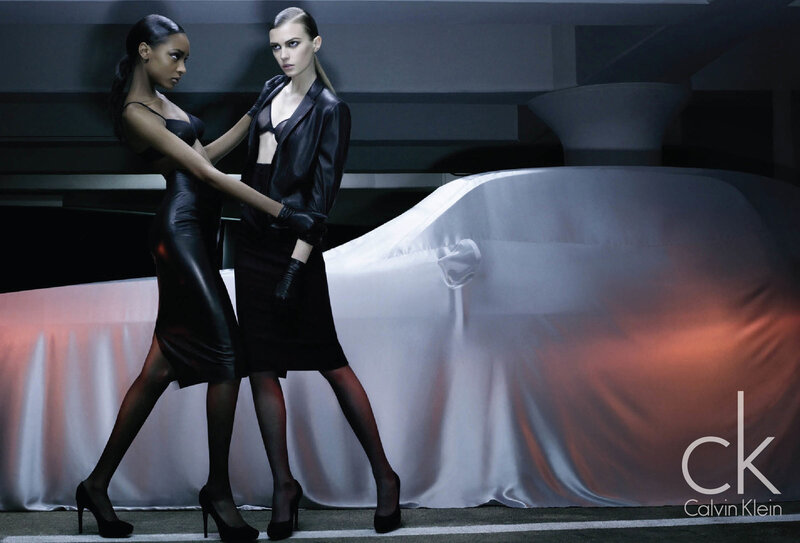 Two models in black leather near a car