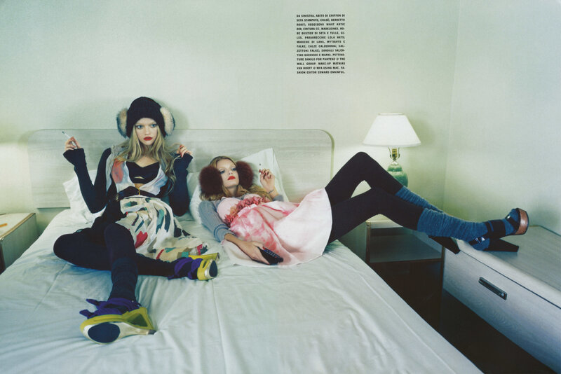 Two models on a bed in fashion shoot