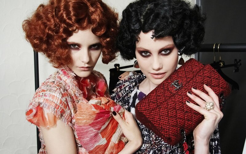 Two models with bold makeup and wigs