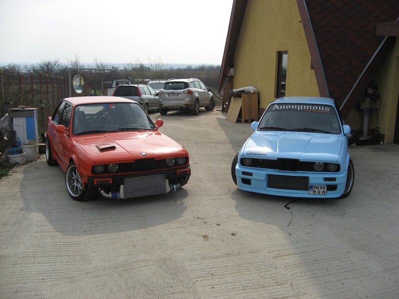 Two modified BMW cars in a driveway