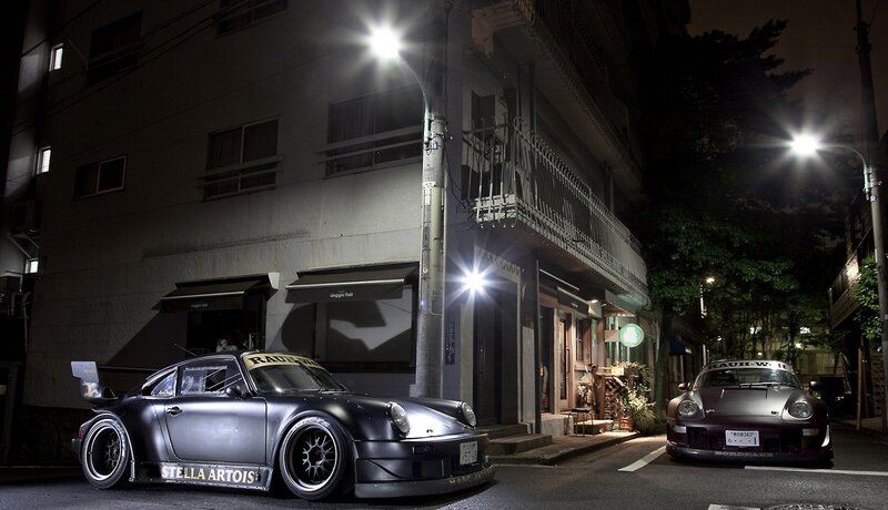 Two modified cars at night