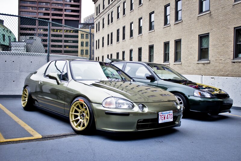 Two modified cars in a parking lot