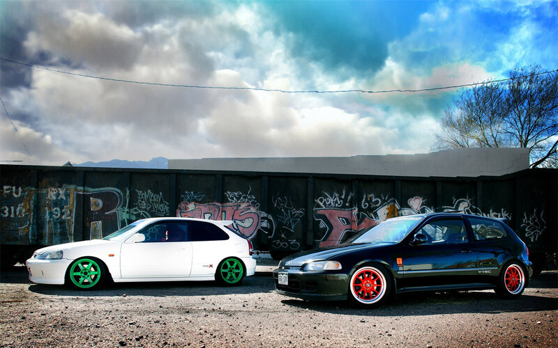Two modified cars in an urban setting