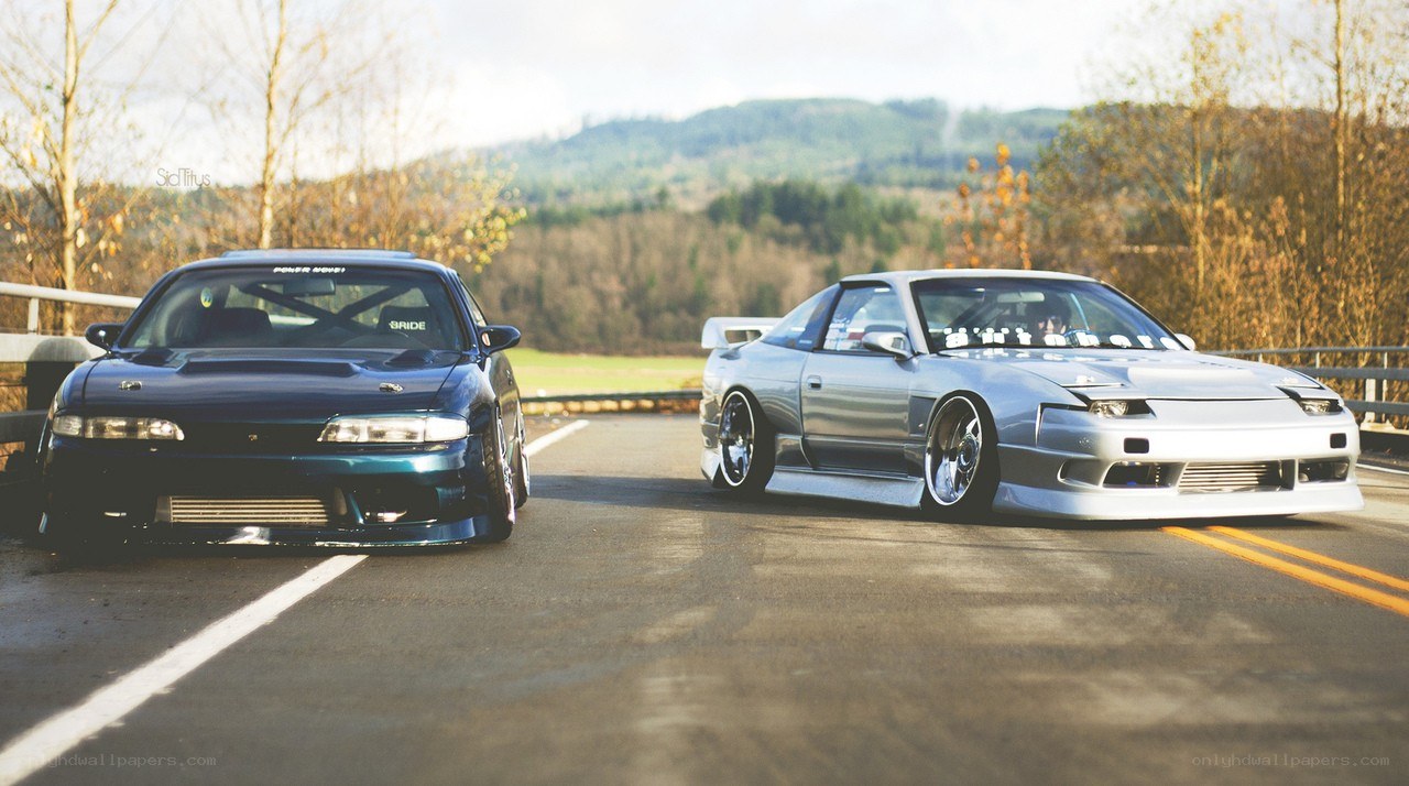Two modified cars on a road