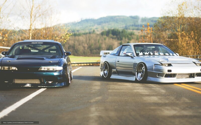 Two modified cars on a road