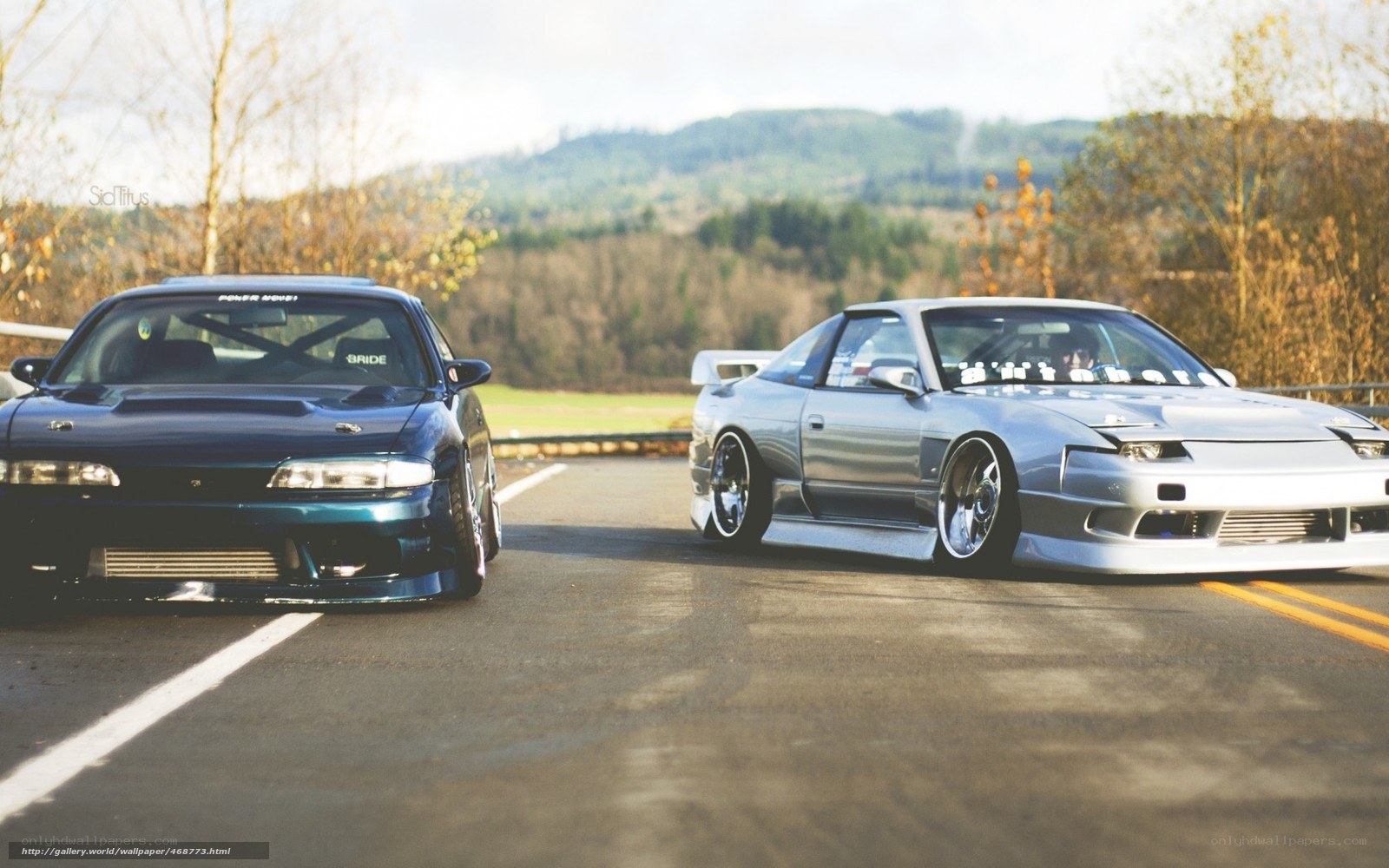 Two modified cars on a road