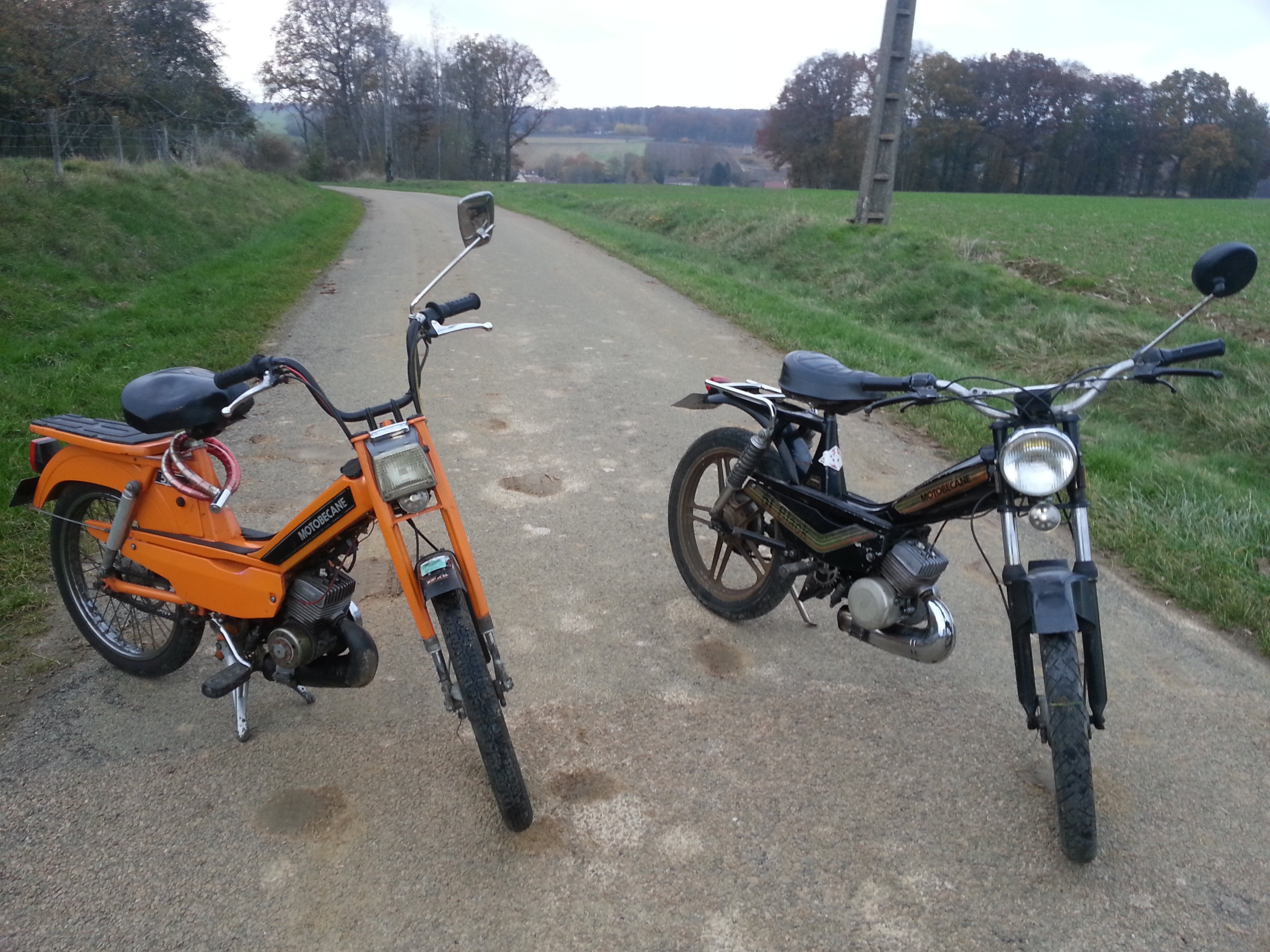 Two mopeds on a rural road