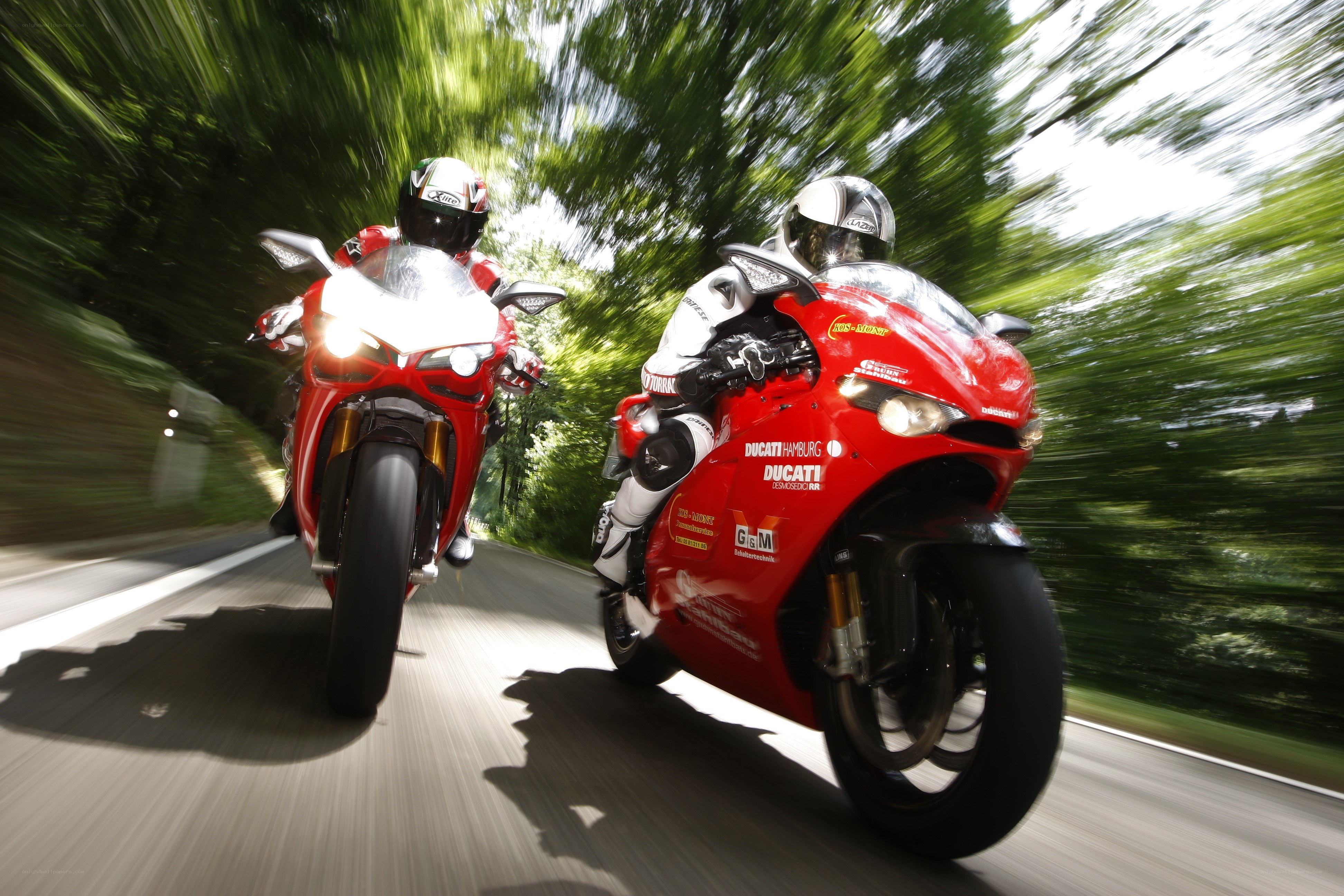 Two motorcyclists on red bikes