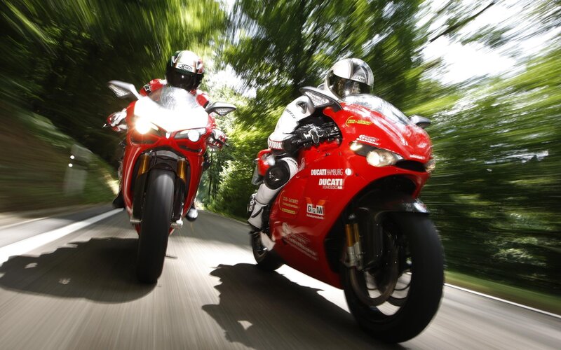 Two motorcyclists on red bikes