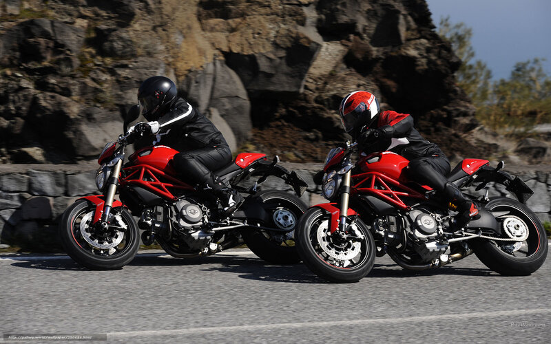 Two motorcyclists on red bikes