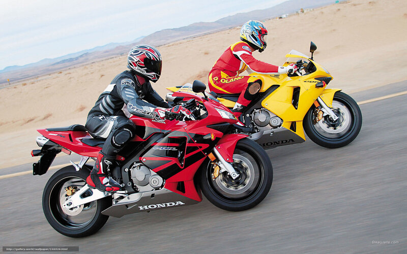 Two motorcyclists racing on a desert road