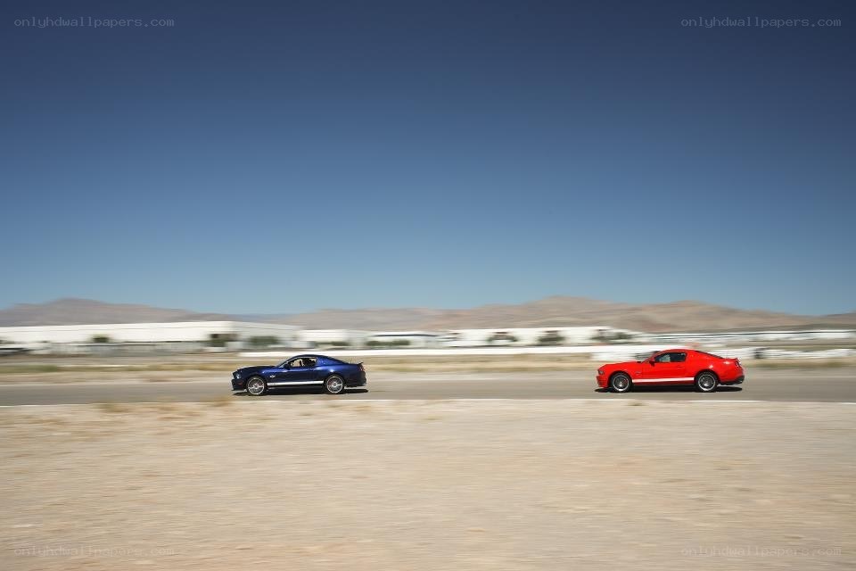 Two Mustangs racing on a track