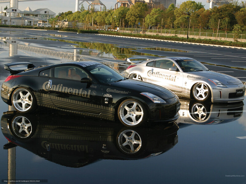 Two Nissan sports cars on wet pavement