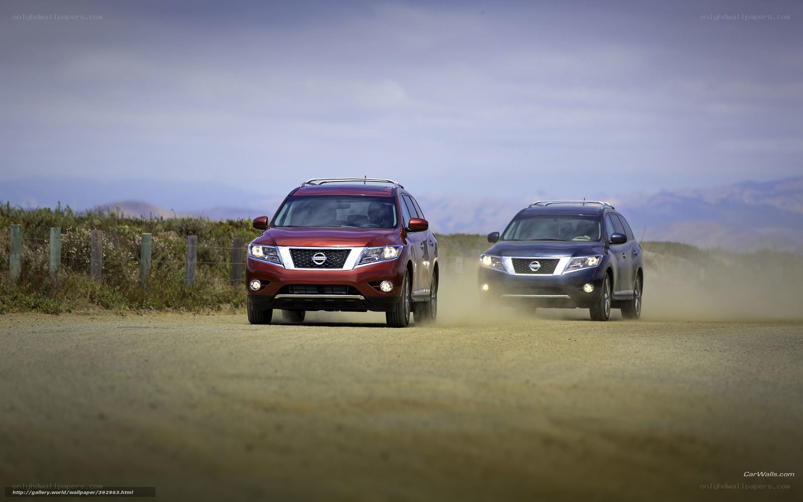 Two Nissan SUVs on a dirt road