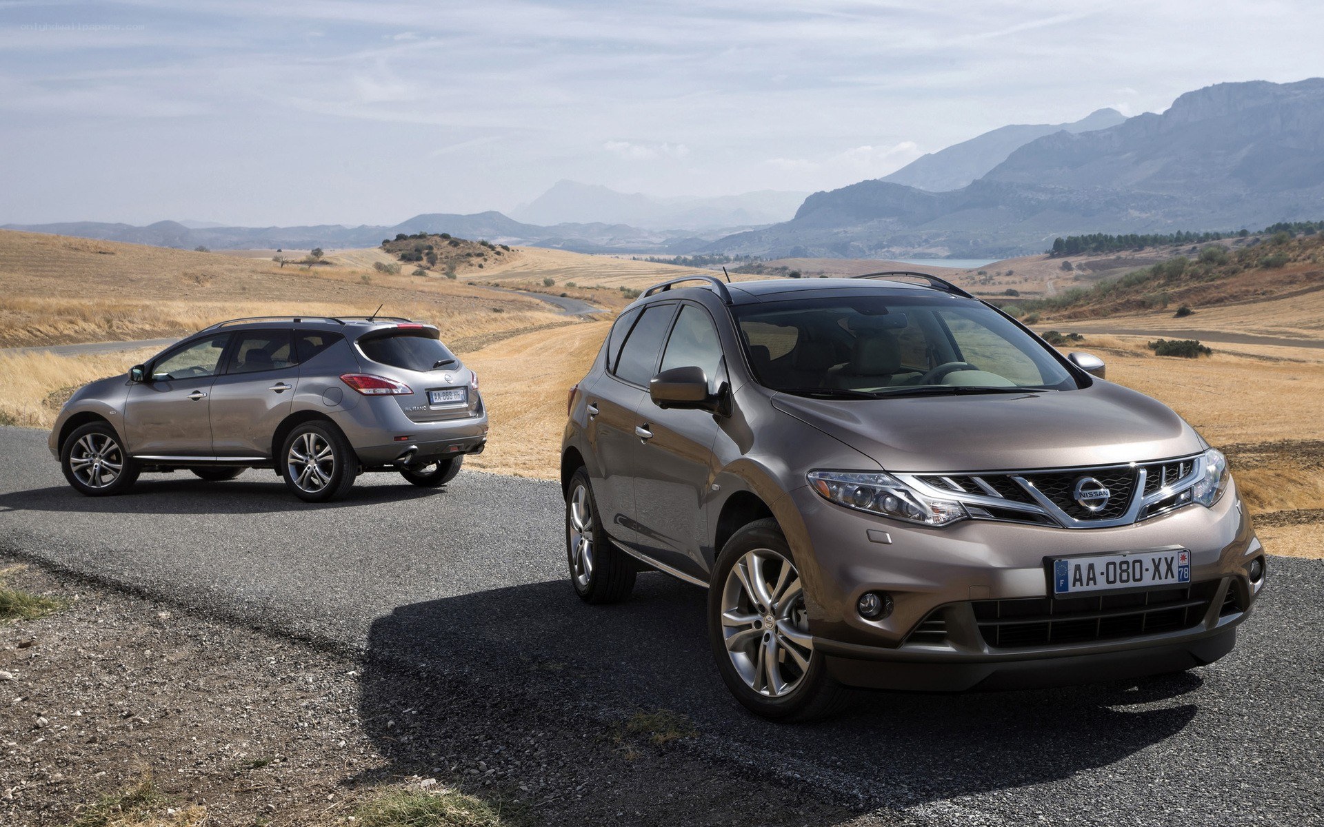 Two Nissan SUVs on a scenic road