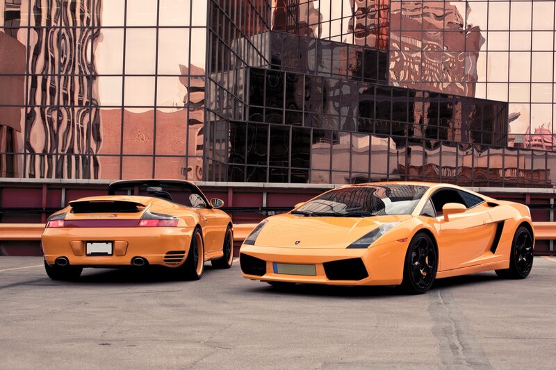 Two orange sports cars parked