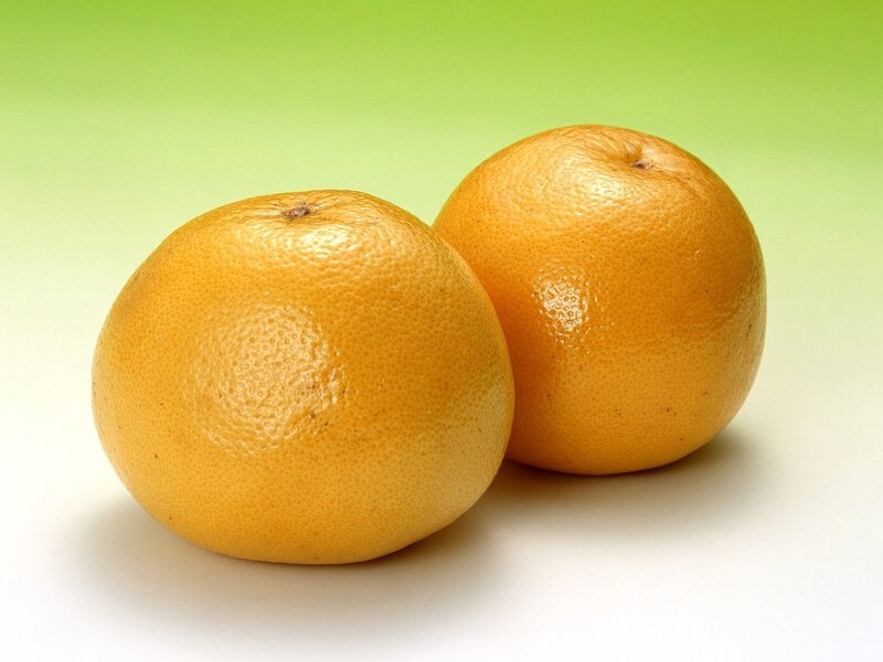 Two oranges on green background
