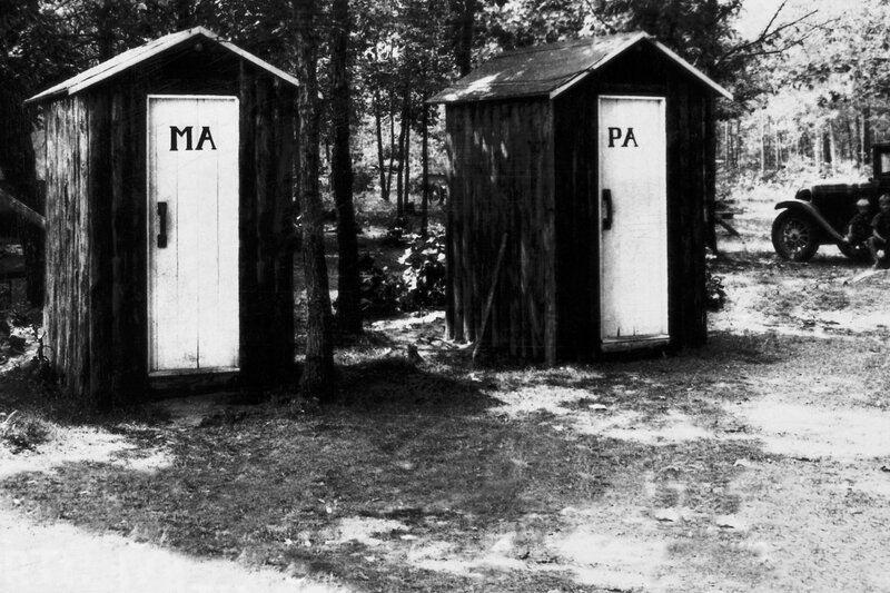 Two outhouses in a wooded area