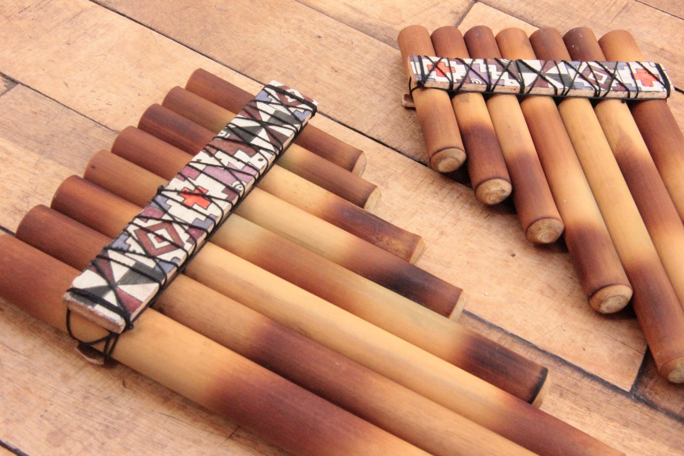 Two panpipes on wooden surface