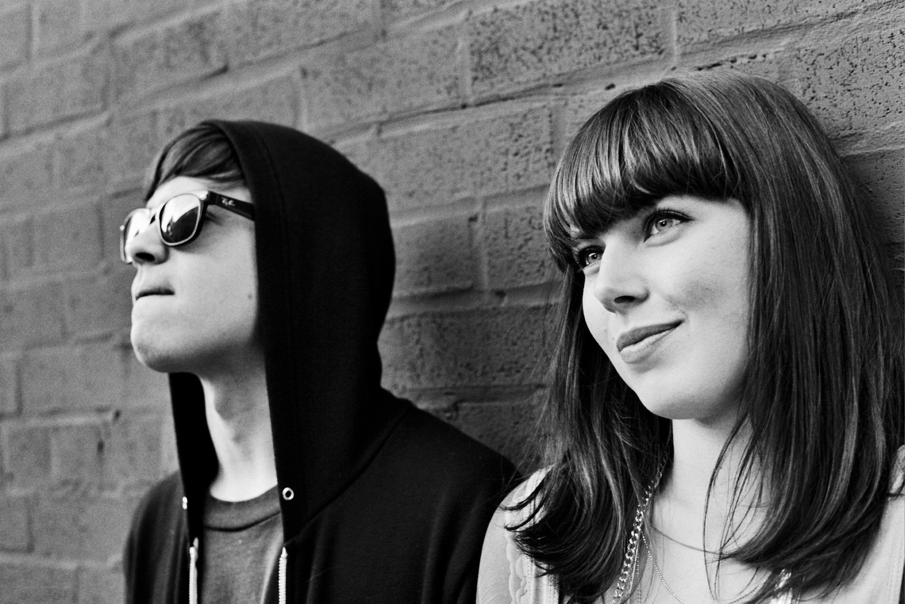 two people against a brick wall