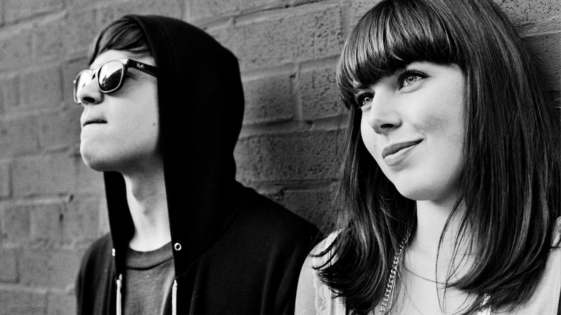 two people against a brick wall