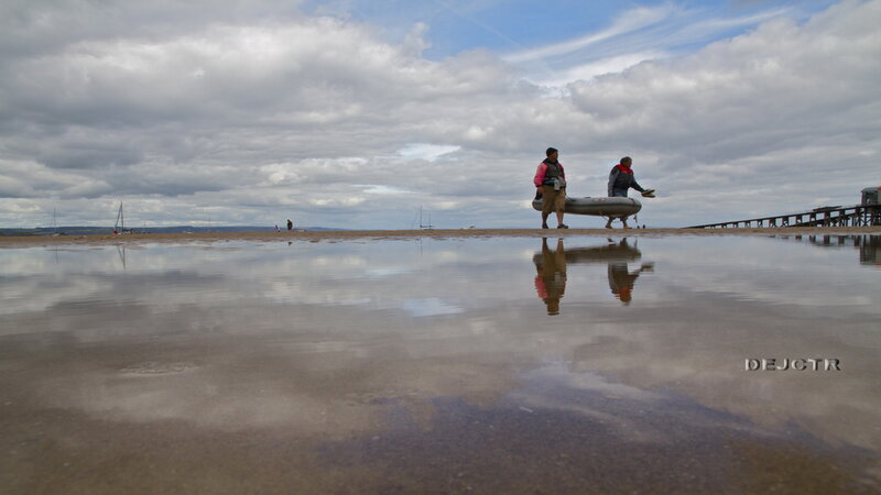 Two People Carrying Boat