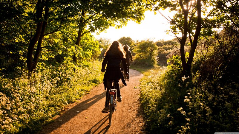 Two People Cycling on Path