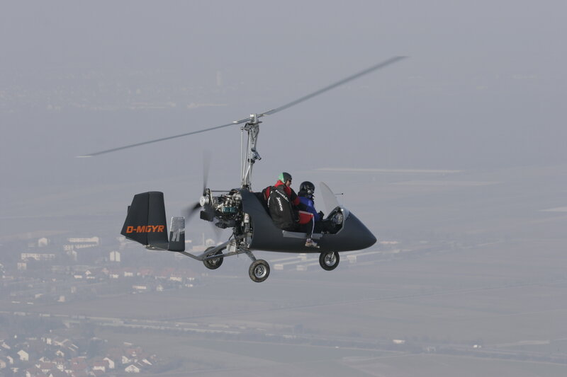 Two people flying a gyrocopter