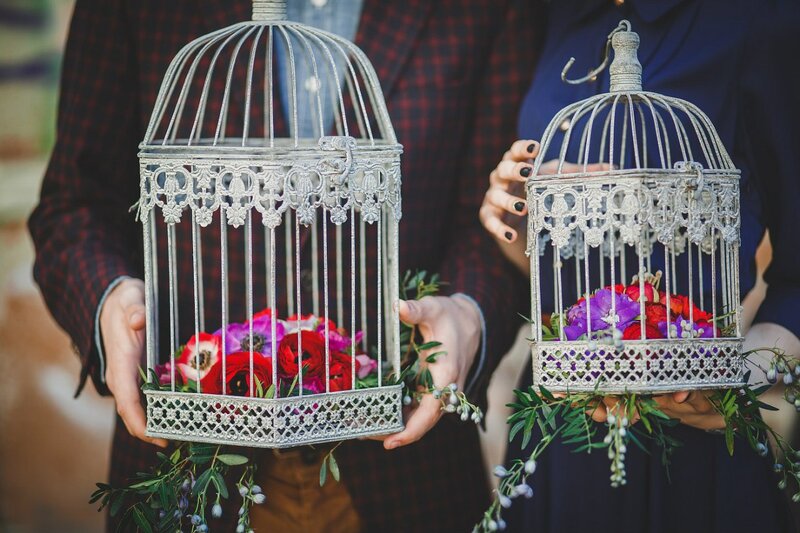 Two People Holding Birdcages