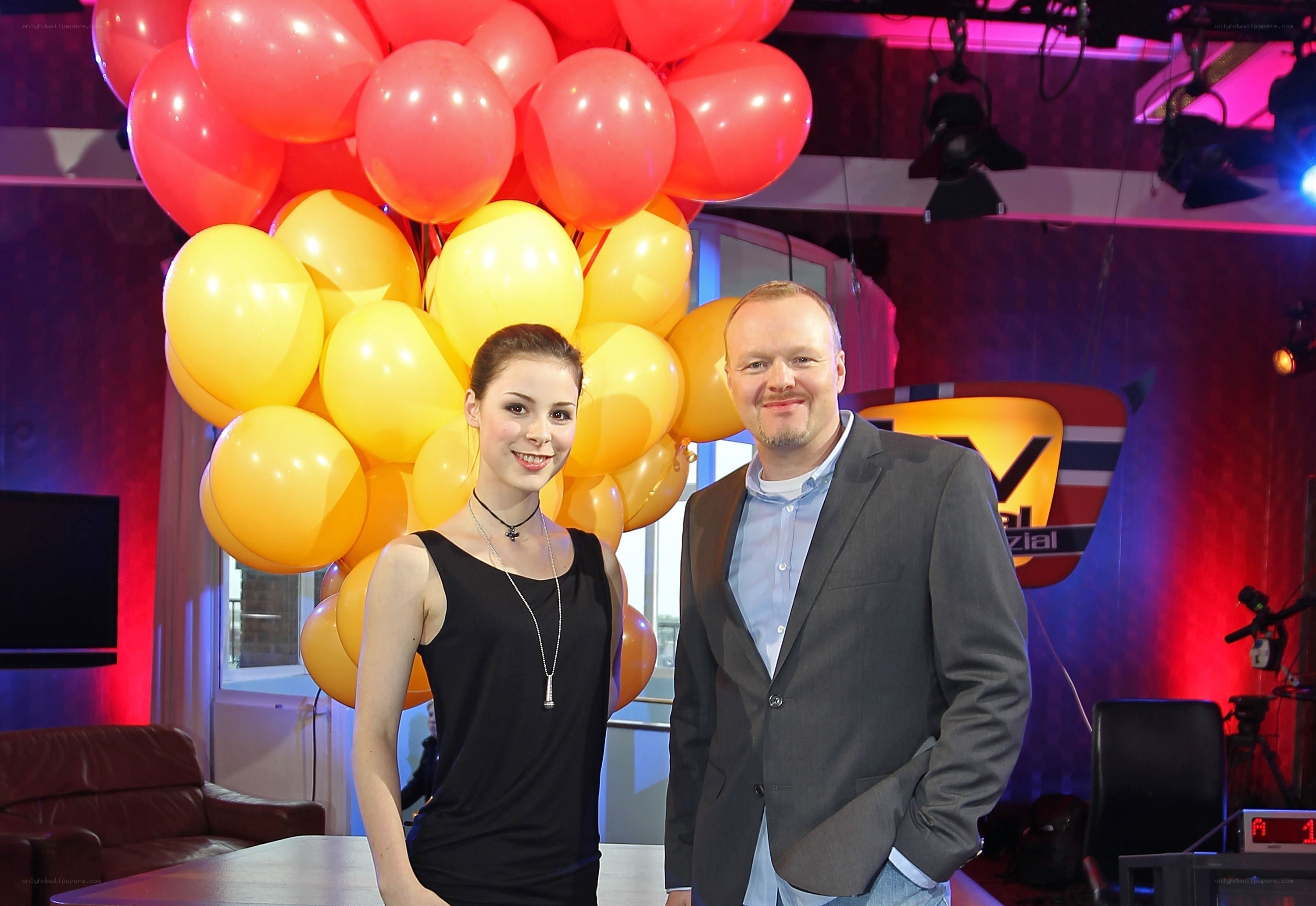 Two people in a studio with balloons