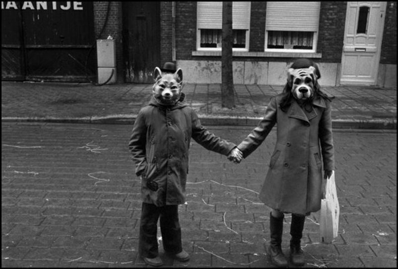 Two people in animal masks holding hands