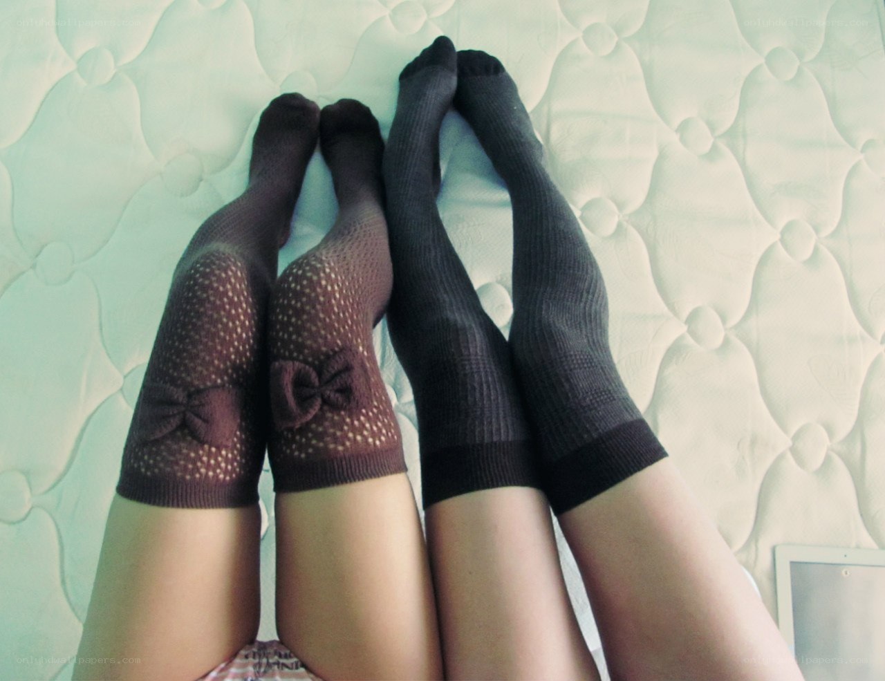 two people in socks on a bed