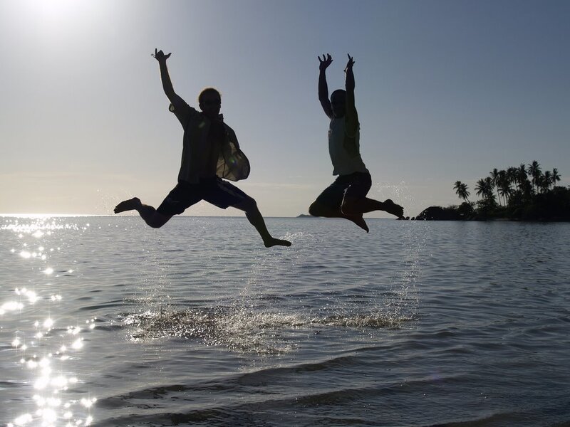 Two people jumping on a beach
