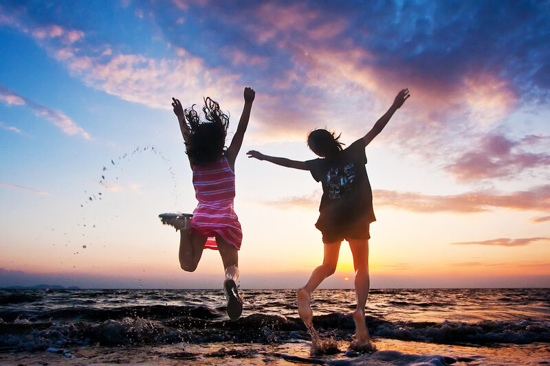 Two People Jumping on Beach