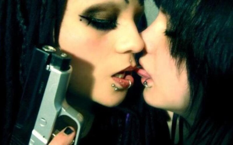 two people kissing with a gun