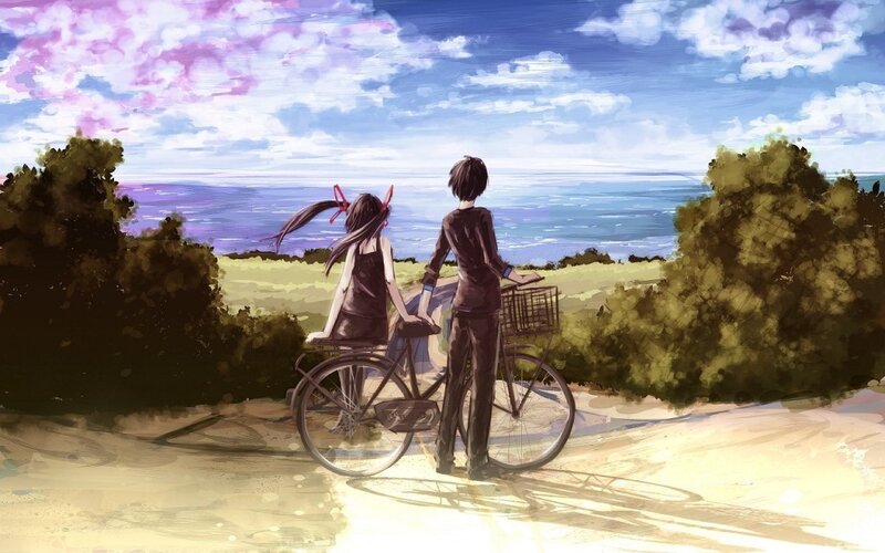 Two people on a bike by the sea