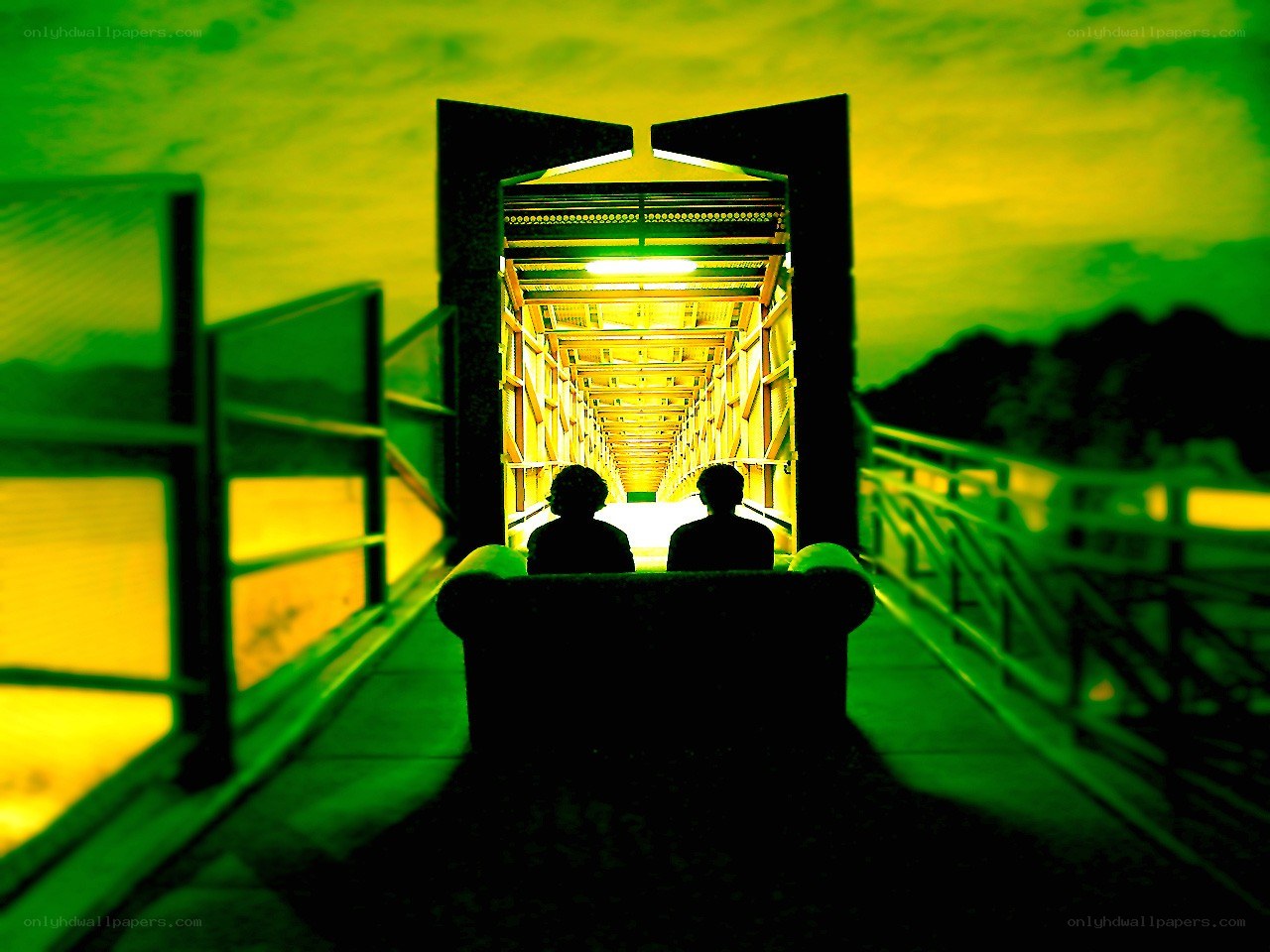 Two people on a bridge at night