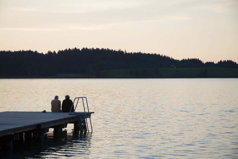 Two people on a dock at sunset