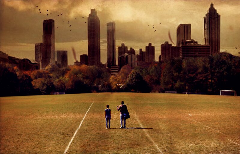 Two people on a field with city skyline