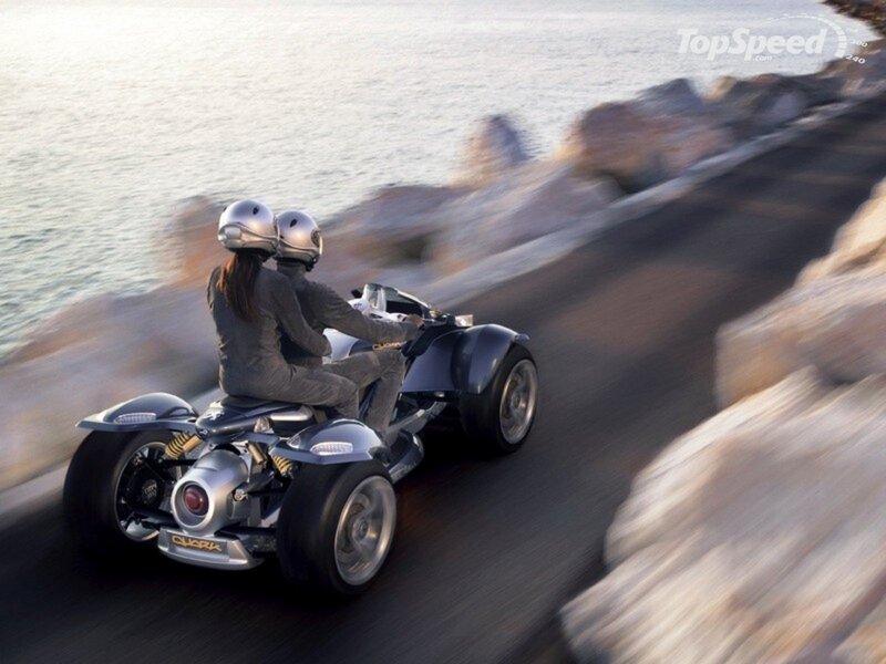 Two people on a three-wheeled vehicle