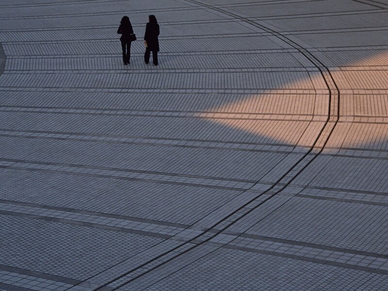 Two people on a tiled plaza