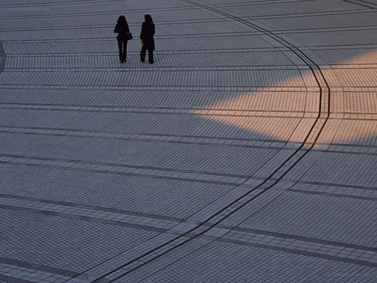 Two people on a tiled plaza