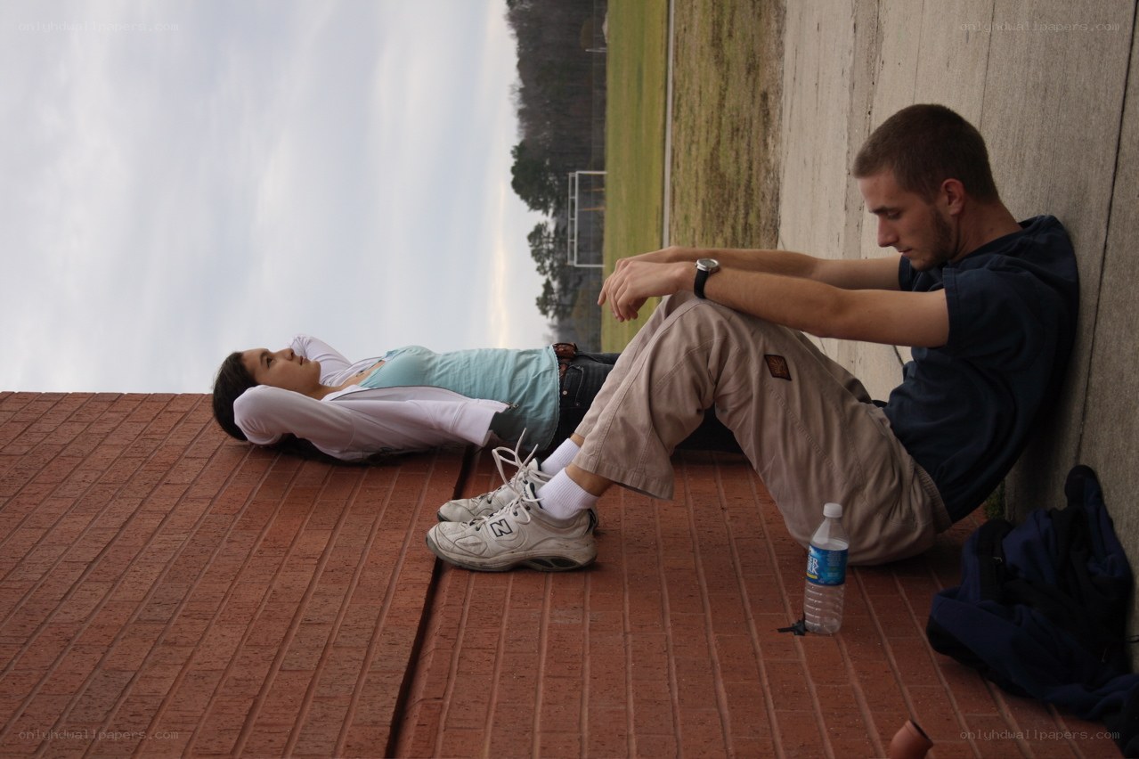 Two people resting on a brick wall