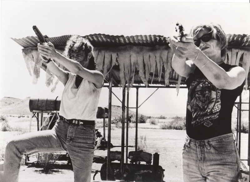 Two people shooting guns at range
