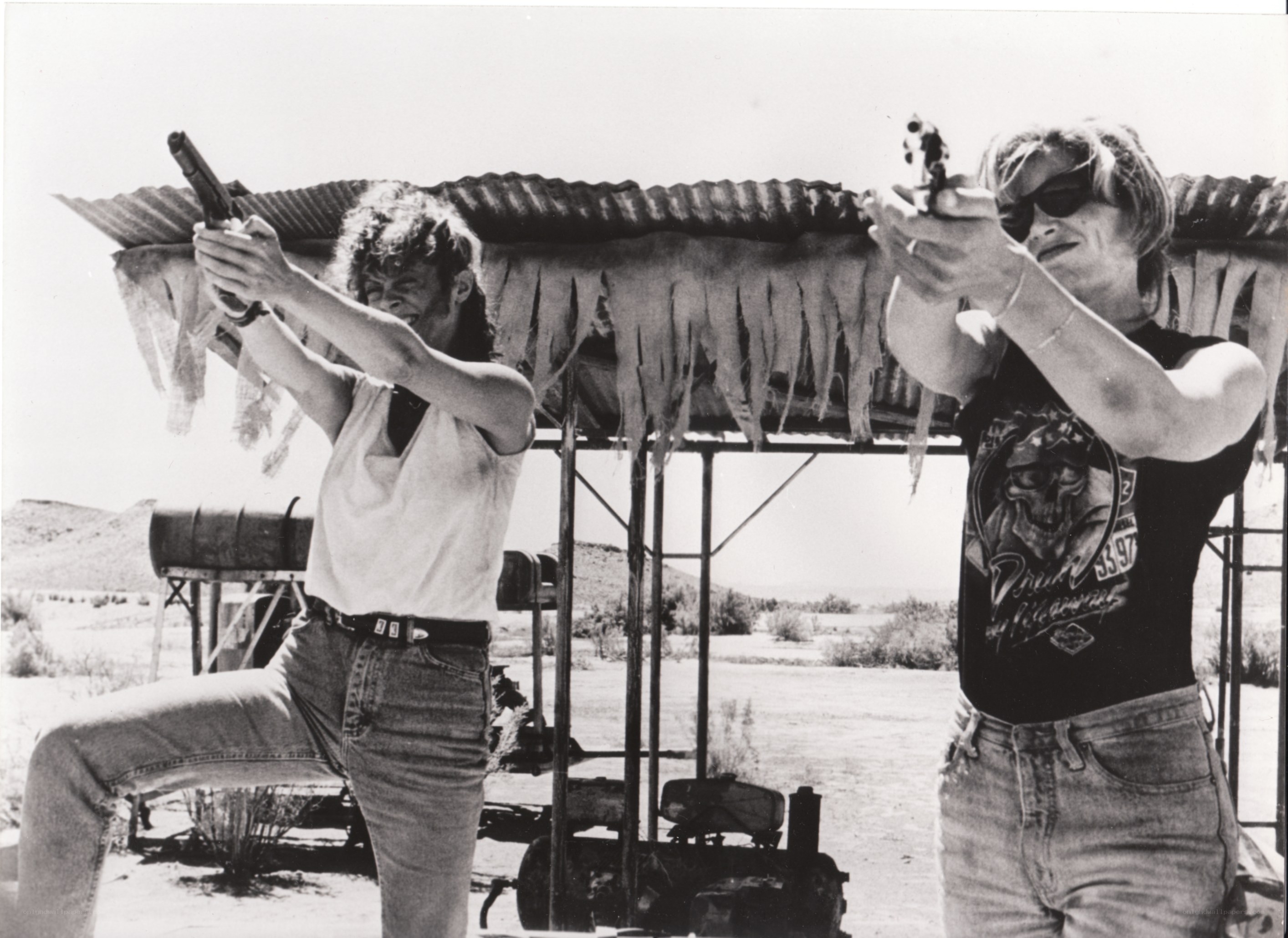 Two people shooting guns at range